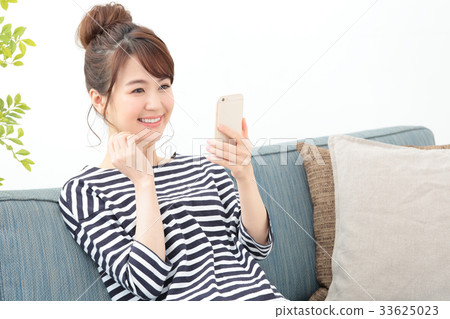 放鬆在沙發的婦女·智能手機 放鬆在沙發的婦女·智能手機 33625023