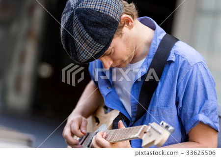 Young musician with guitar in city Young musician with guitar in city 33625506
