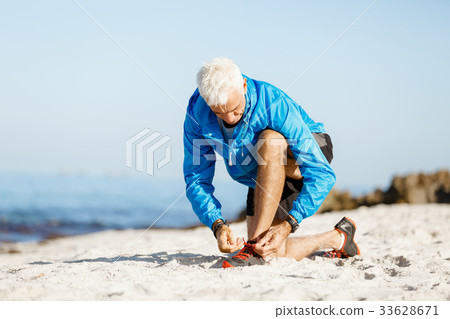 Runner laces his shoes and prepares to jogging Runner laces his shoes and prepares to jogging 33628671
