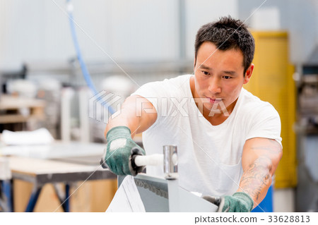 Asian worker in production plant on the factory floor 33628813
