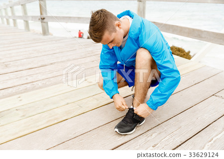 Runner laces his shoes and prepares to jogging 33629124