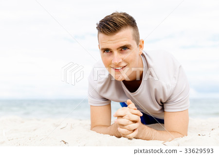 Man training on beach outside 33629593