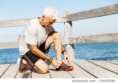 Runner laces his shoes and prepares to jogging 33629596