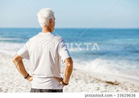 Man standing on beach in sports wear 33629636