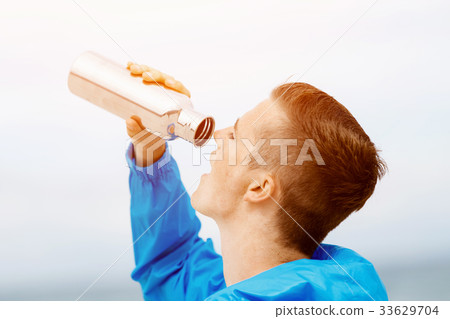 Man drinking from a sports bottle 33629704