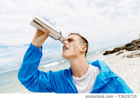Man drinking from a sports bottle 33629720
