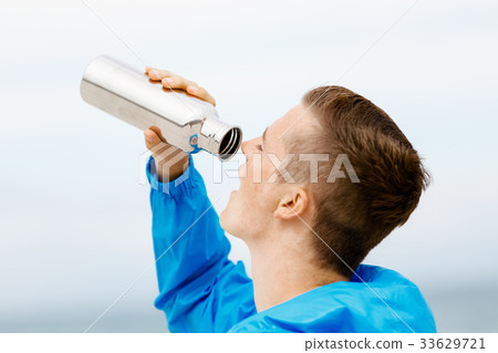 Man drinking from a sports bottle 33629721