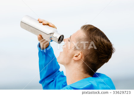 Man drinking from a sports bottle 33629723