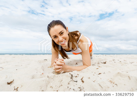 Young woman training on beach outside 33629750