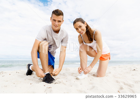 Runners lace their shoes and prepare to jogging 33629965
