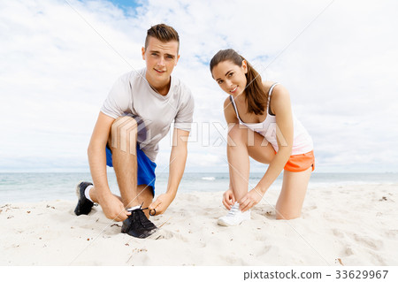 Runners lace their shoes and prepare to jogging 33629967