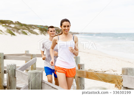 Runners. Young couple running on beach Runners. Young couple running on beach 33630199