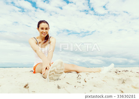 Young woman training on beach outside 33630281