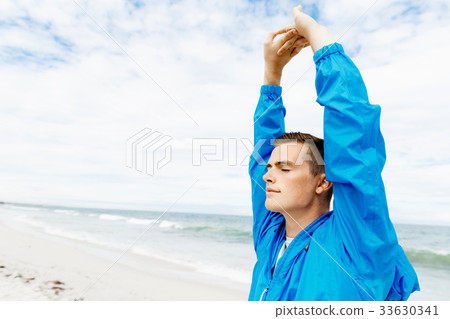 Man training on beach outside 33630341