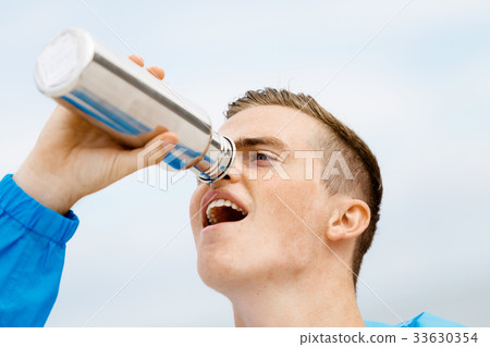 Man drinking from a sports bottle 33630354