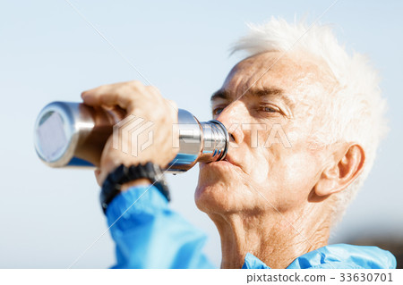 Man drinking from a sports bottle 33630701