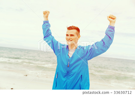 Young man in sport wear with outstretched arms Young man in sport wear with outstretched arms 33630712