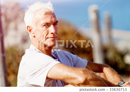 Man in sports wear sitting at the beach Man in sports wear sitting at the beach 33630713