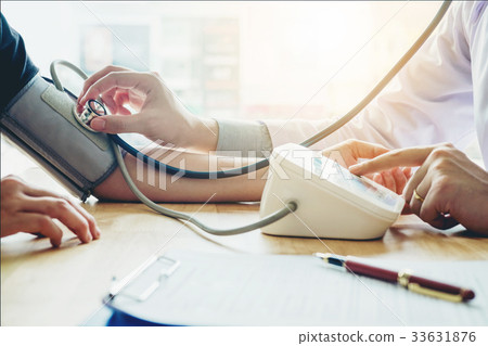 Doctor Measuring arterial blood pressure patient  33631876