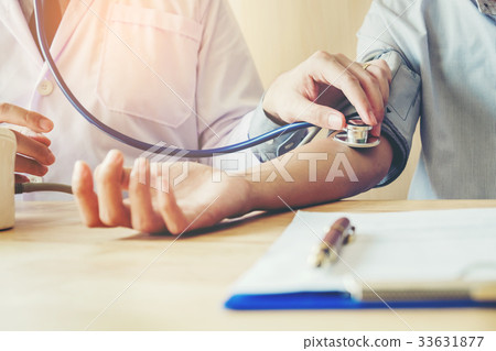 Doctor Measuring arterial blood pressure patient  33631877