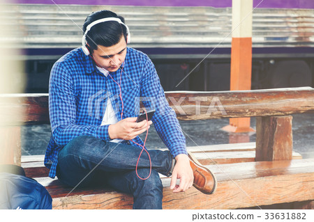 Travel man using mobile phone at train station 33631882