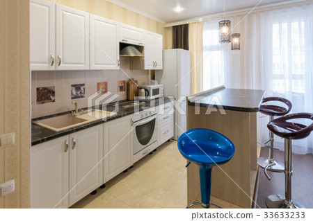 Interior of a one-room apartment, view of a kitchen set and a bar counter Interior of a one-room apartment, view of a kitchen set and a bar counter 33633233