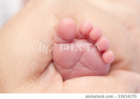 Baby feet in hands 33634270