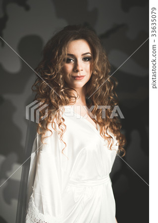 Gorgeous bride in robe posing and preparing for Gorgeous bride in robe posing and preparing for 33635079