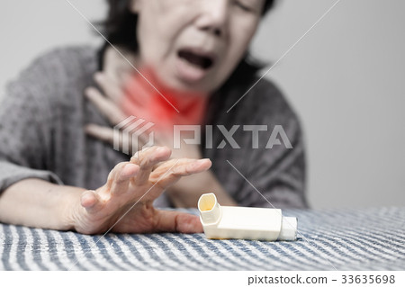 Elderly woman choking and holding an asthma spray 33635698