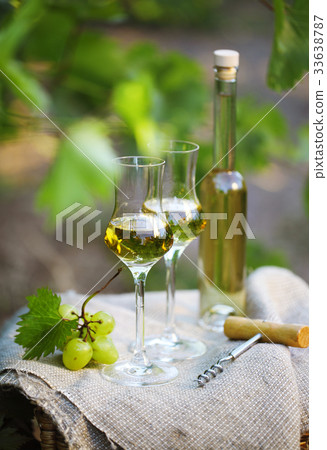 Grappa and glasses with bunch of grapes 33638787