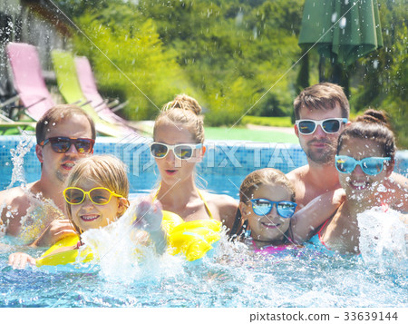 Young people with kids having fun in the pool. 33639144