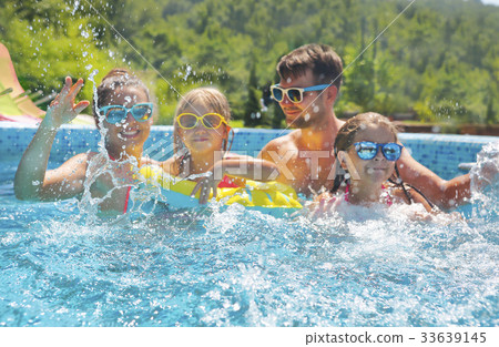 Happy family with kids having fun in the pool. 33639145