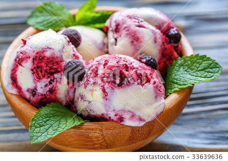 Balls of vanilla ice cream with black currants. 33639636