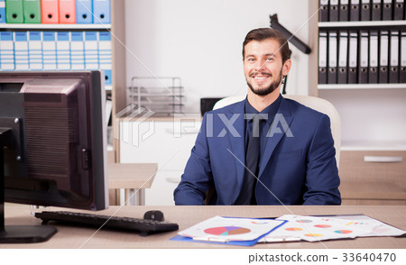 Smiling entrepreneur in business suit at his work Smiling entrepreneur in business suit at his work 33640470
