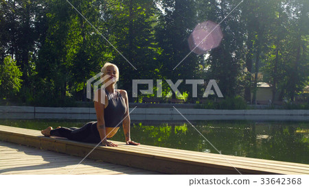Young woman doing yoga exercises in the park 33642368