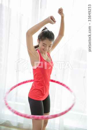 Asian women  playing hula hoop at home. 33649253