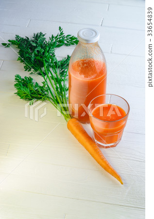 A bottle of carrot juice with with a stuffed glass A bottle of carrot juice with with a stuffed glass 33654839
