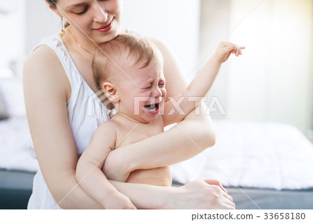 Woman with crying baby Woman with crying baby 33658180