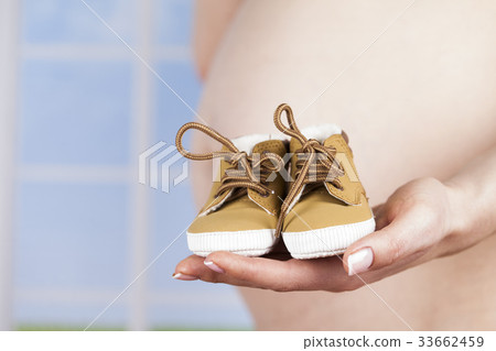 Pregnancy concept, female hands shoes Pregnancy concept, female hands shoes 33662459