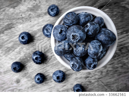 bowl of blueberries on wooden background 33662561
