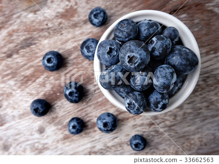 bowl of blueberries on wooden background 33662563