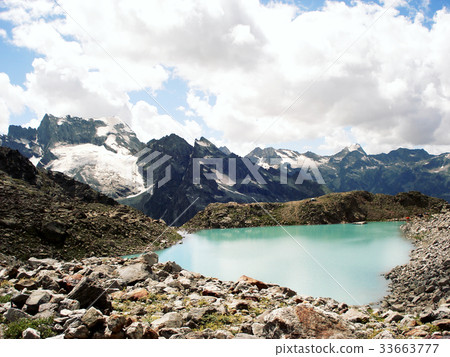 Small blue lake in the mountains. Distant Peaks. 33663777
