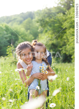 Two happy sisters in the spring field Two happy sisters in the spring field 33664423