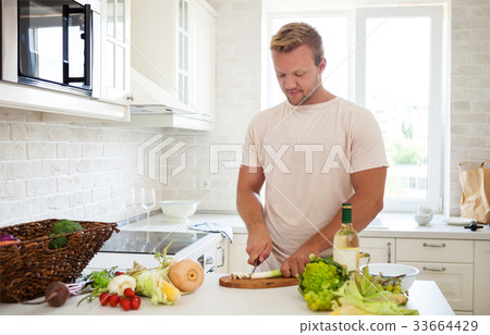 Handsome man cooking at home Handsome man cooking at home 33664429
