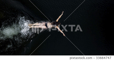 Young female swimming underwater 33664747