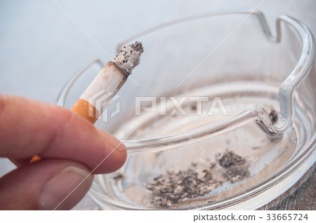hand of man with cigarette and ashtray hand of man with cigarette and ashtray 33665724