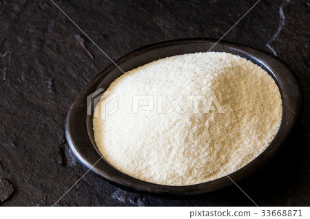 Maize flour (Zea mays) in a black clay dish 33668871