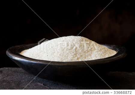 Maize flour (Zea mays) in a black clay dish 33668872