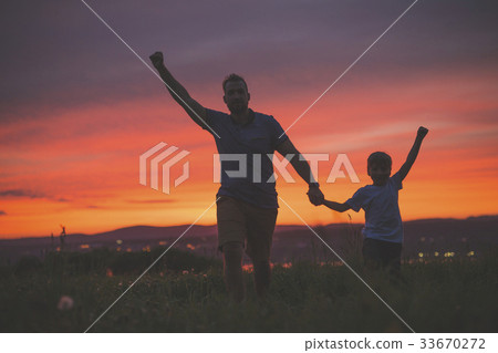 silhouette of father and son at sunset 33670272