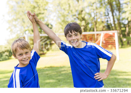Two Young boy with soccer ball on a sport uniform Two Young boy with soccer ball on a sport uniform 33671294